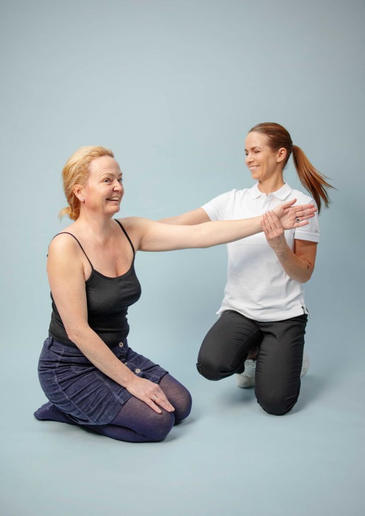 Fysioterapeut som viser en øvelse