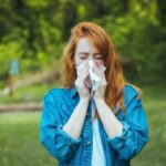 Person som snyter seg på grunn av allergi